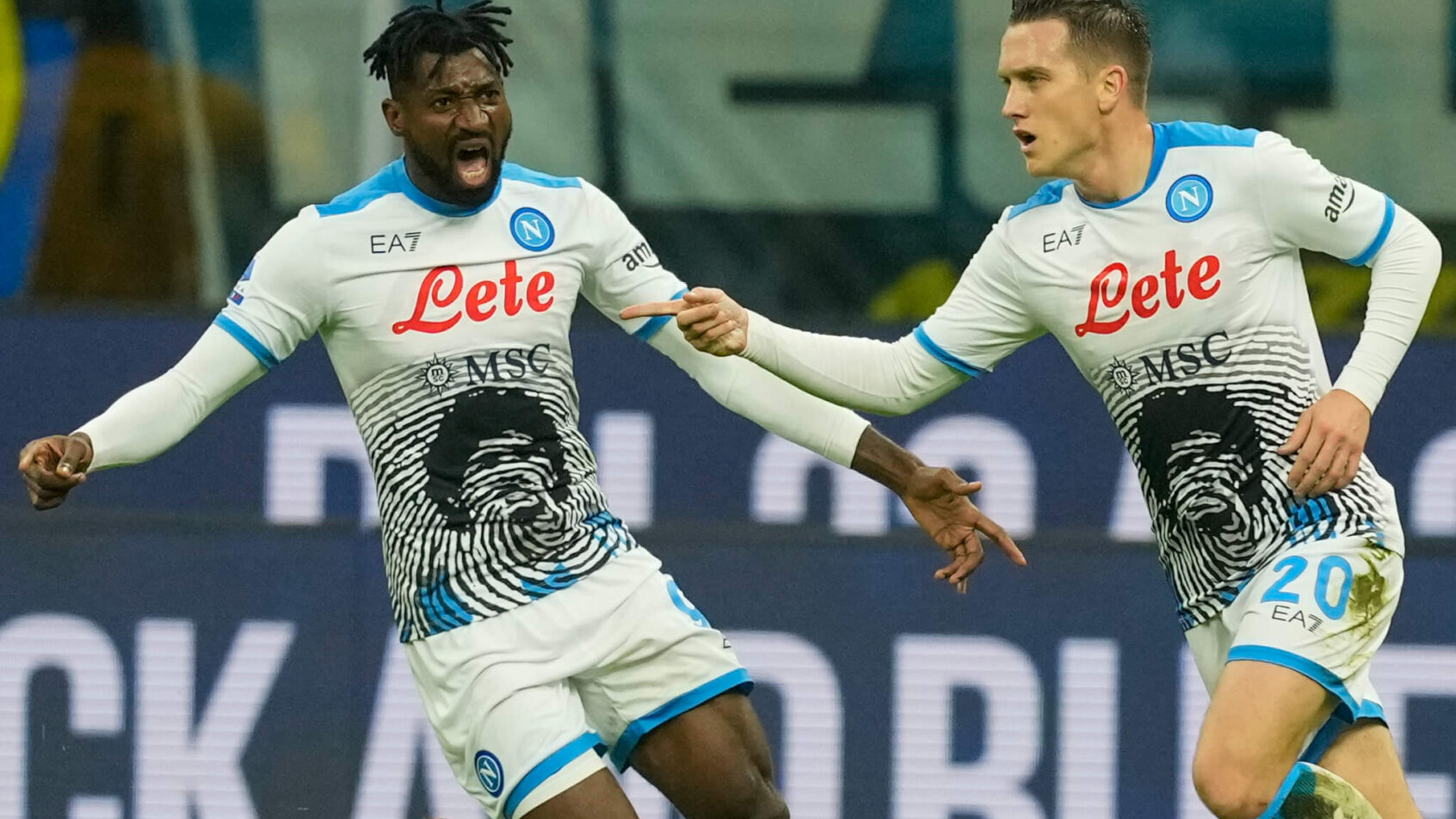 Napoli's Piotr Zielinski celebrating with his teammate after scoring a goal.