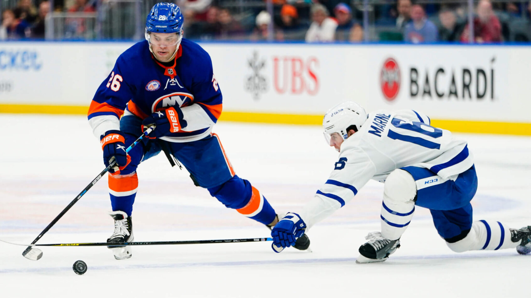 Mitch Marner fighting for control of the puck during an NHL game.