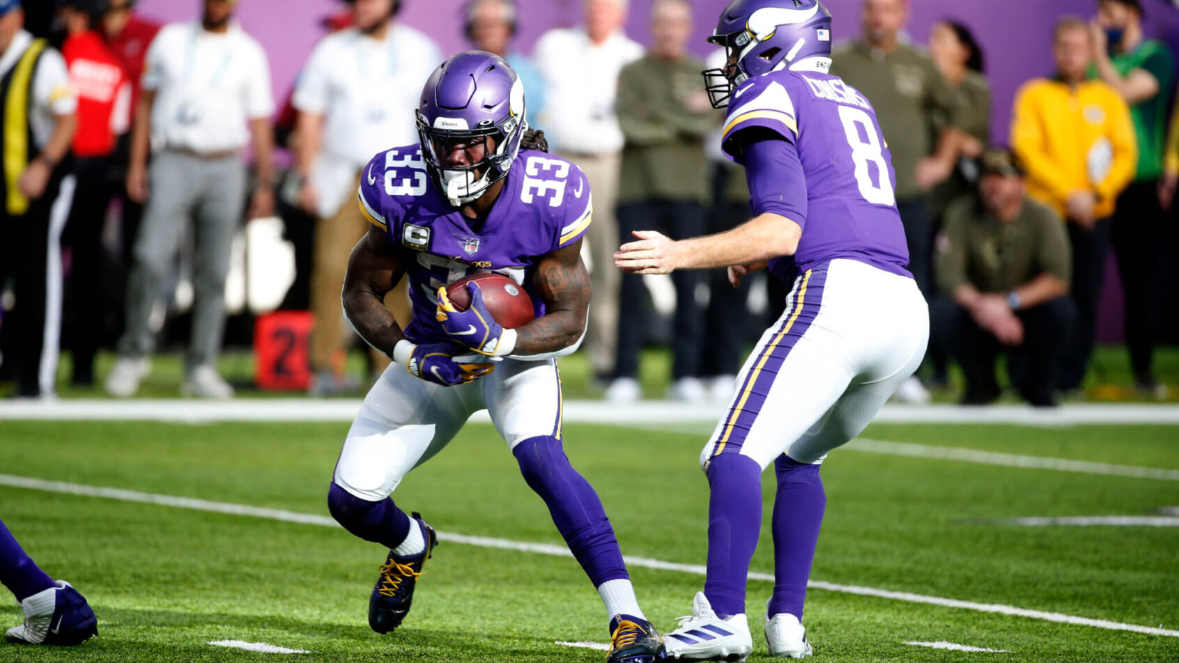 Minnesota Vikings quarterback Kirk Cousins handing the ball off to Dalvin Cook during a football game.