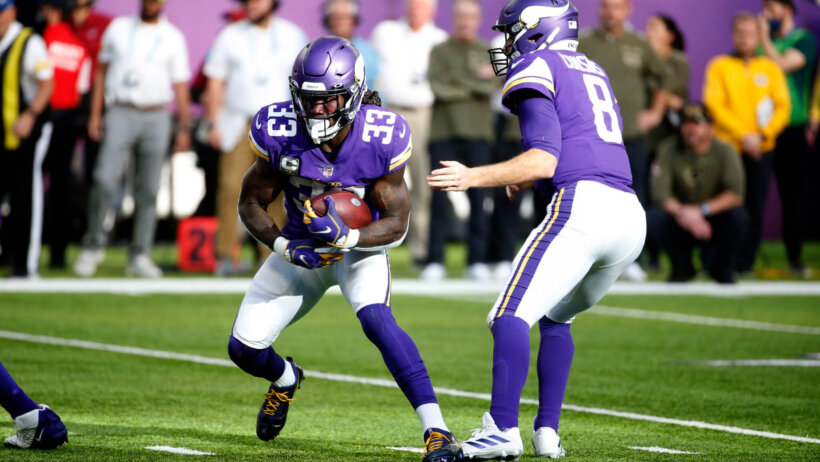 Minnesota Vikings quarterback Kirk Cousins handing the ball off to Dalvin Cook during a football game.