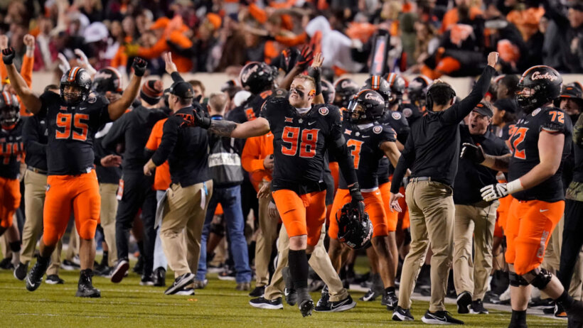 Oklahoma State players celebrating on the field during a football game.