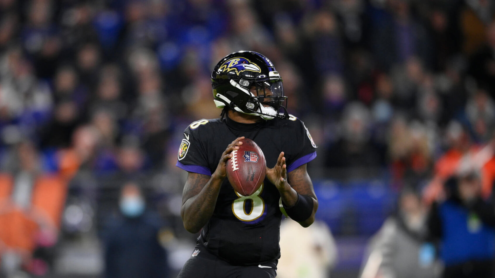 Baltimore Ravens quarterback Lamar Jackson looking to throw the ball during a football game.