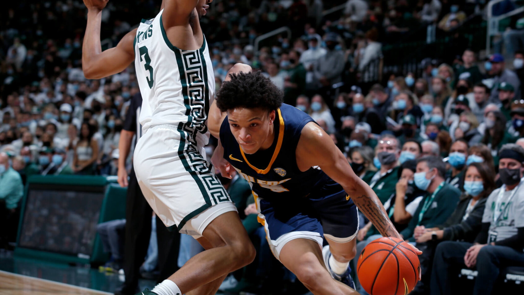 Toledo's Ryan Rollins driving pas a Michigan State defender