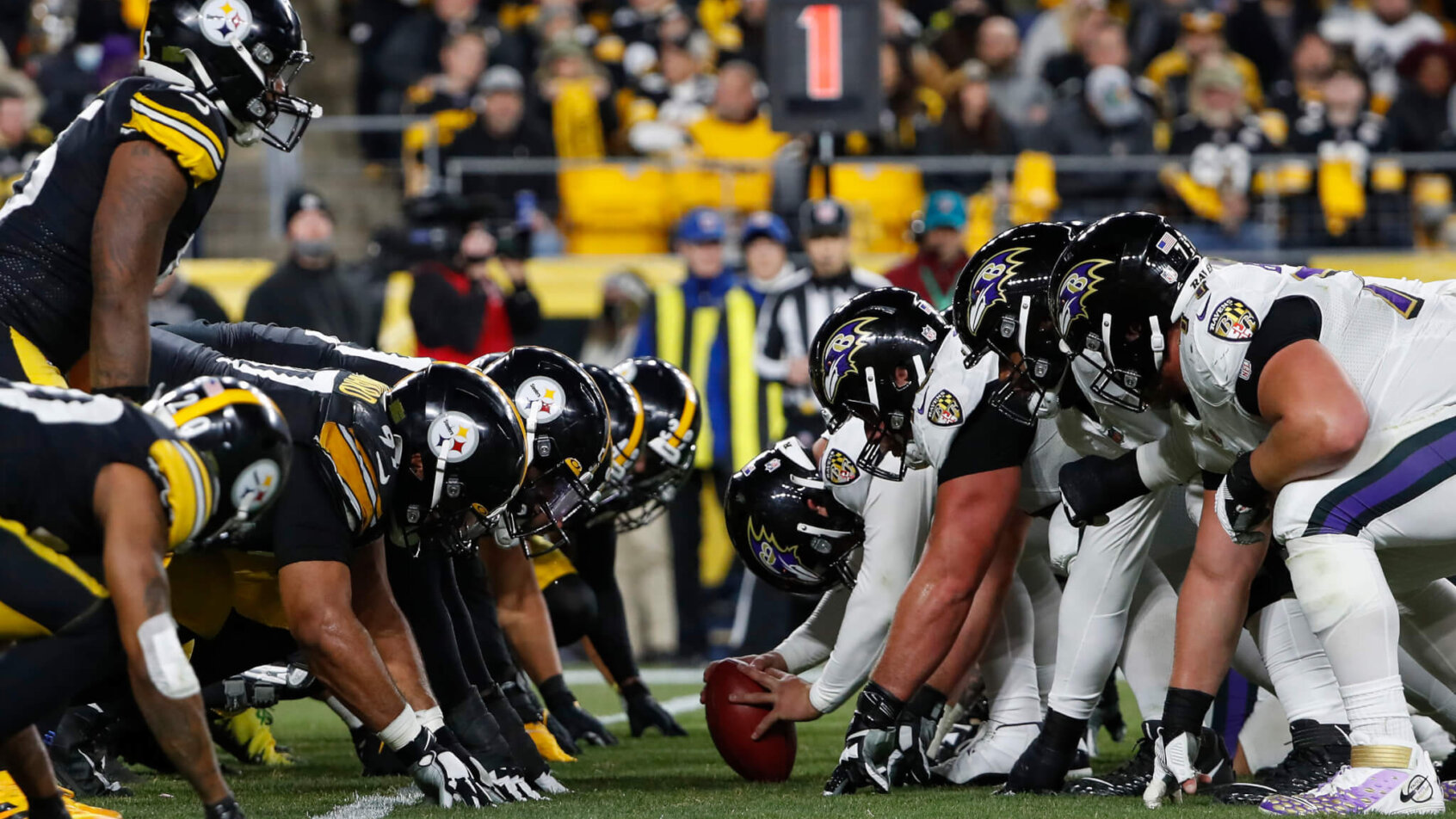 The Baltimore Ravens and the Pittsburgh Steelers lining up at the line of scrimmage.