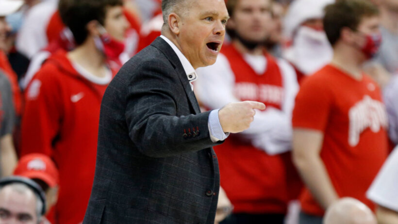 Chris Holtmann talking to someone on court