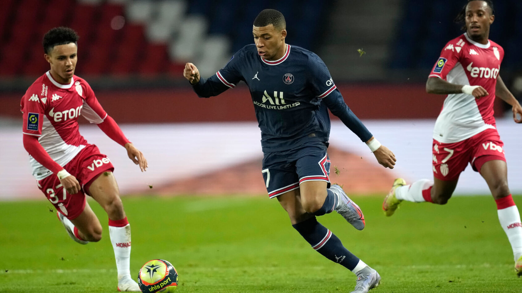 PSG's Kylian Mbappe fighting for the ball against Monaco's Sofiane Diop during a soccer match.