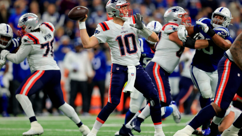New England Patriots quarterback Mac Jones looking to throw the ball during an NFL game.
