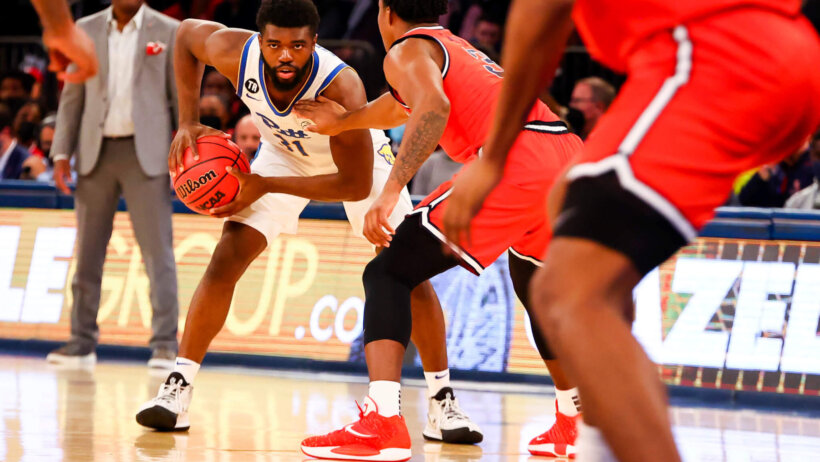 Pittsburgh's guard Jamarius Burton shielding the ball from a defender