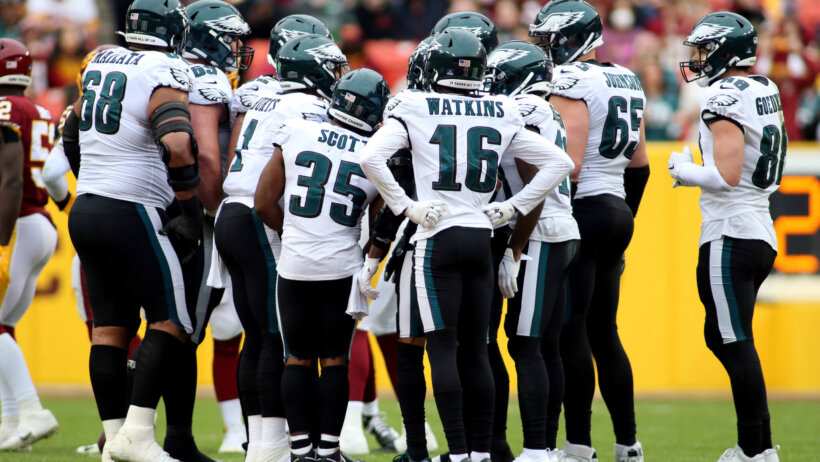 Philadelphia Eagles players huddling up during an NFL football game.