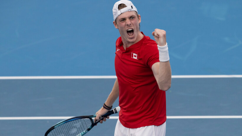 Denis Shapovalov reacting with a fist pump during a tennis match.