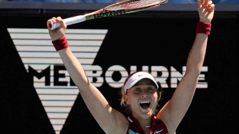 Paula Bados celebrating with her hands up in the air after defeating an opponent during a tennis match.
