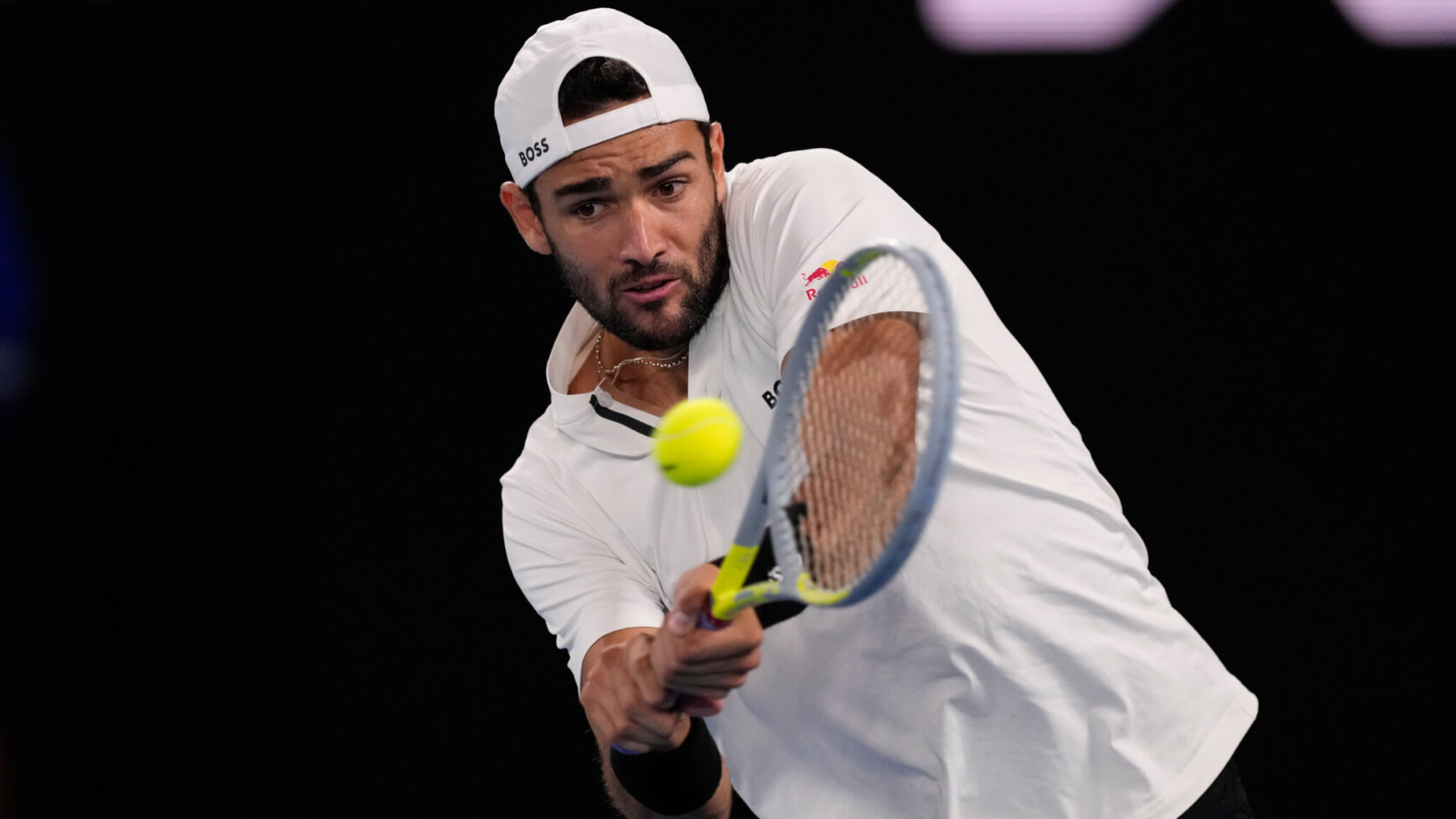 Matteo Berrettini hitting a backhand return during a tennis match.
