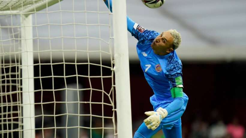 Costa Rica's goalkeeper Keylor Navas diving to save a free kick during a soccer match.