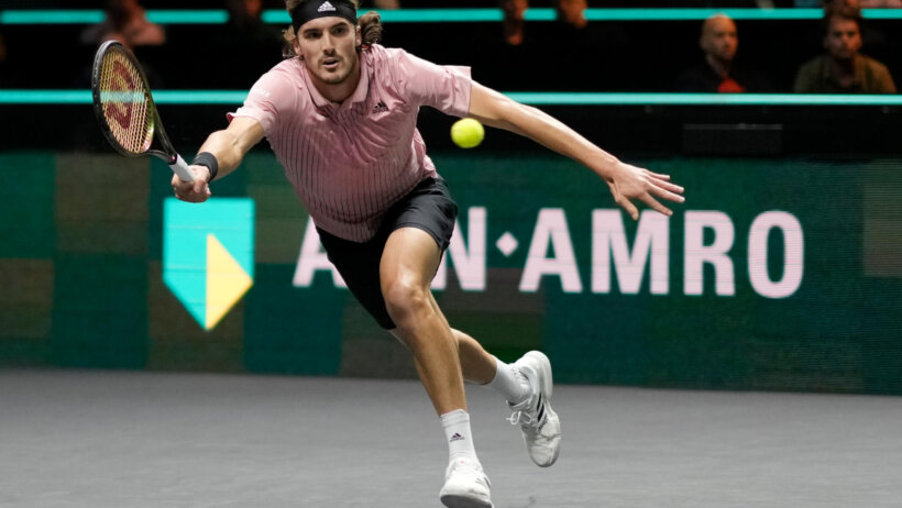 Stefanos Tsitsipas stretching for a shot during a tennis match.