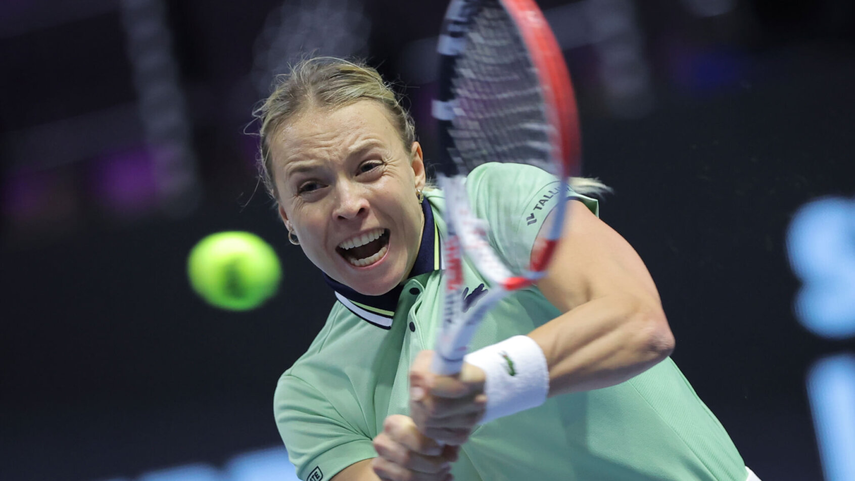 Anett Kontaveit hitting a return shot during a tennis match.