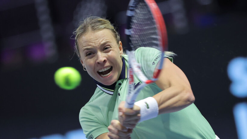 Anett Kontaveit hitting a return shot during a tennis match.