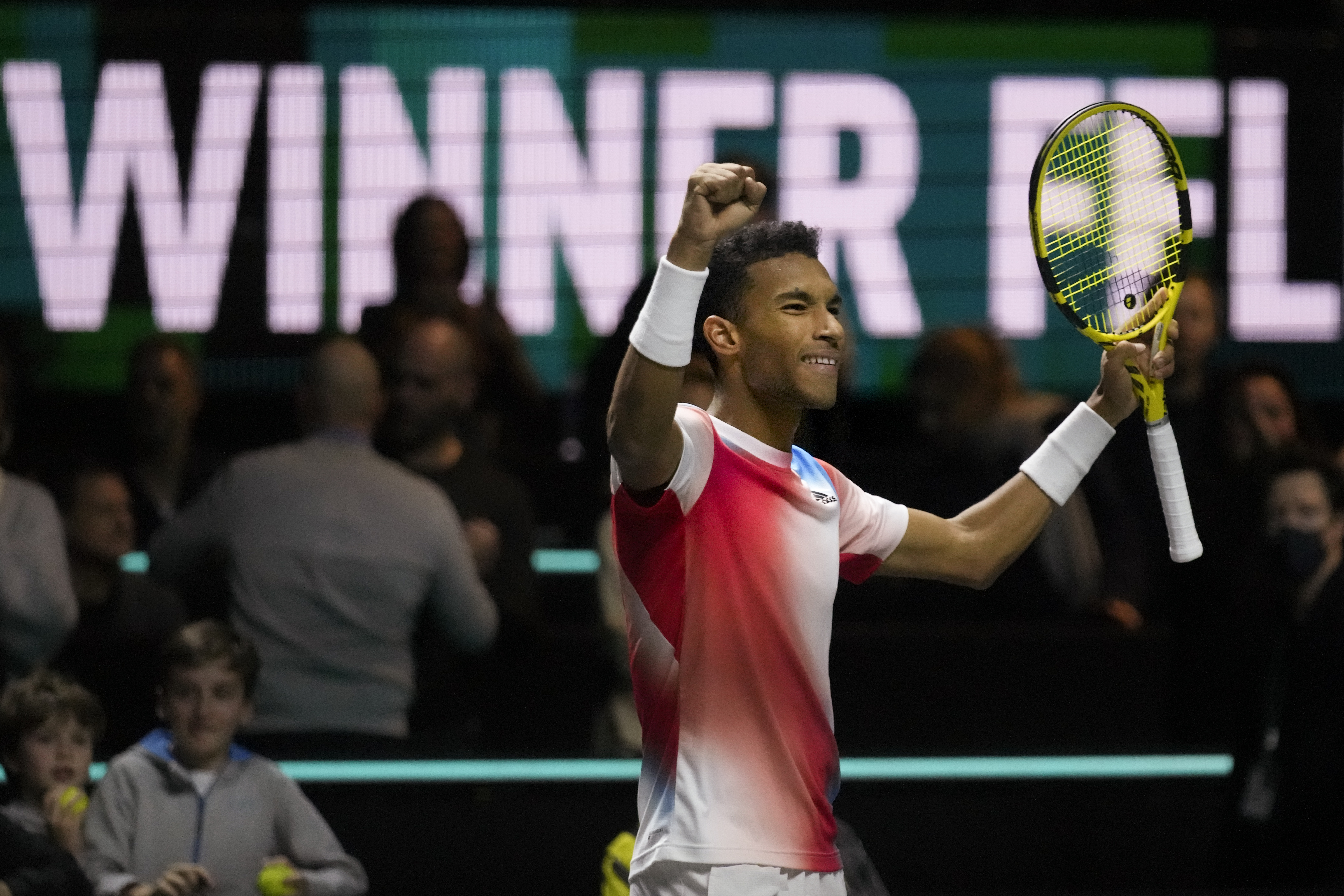 Felix Auger-Aliassime celebrating his win against Andrey Rublev with his hands in the air.