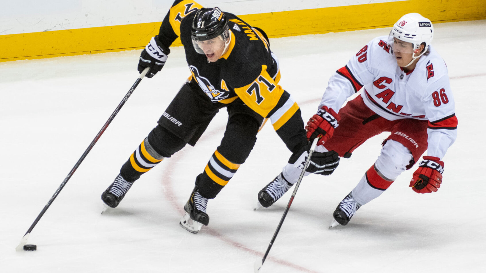 Evgeni Malkin skating while shielding off defender