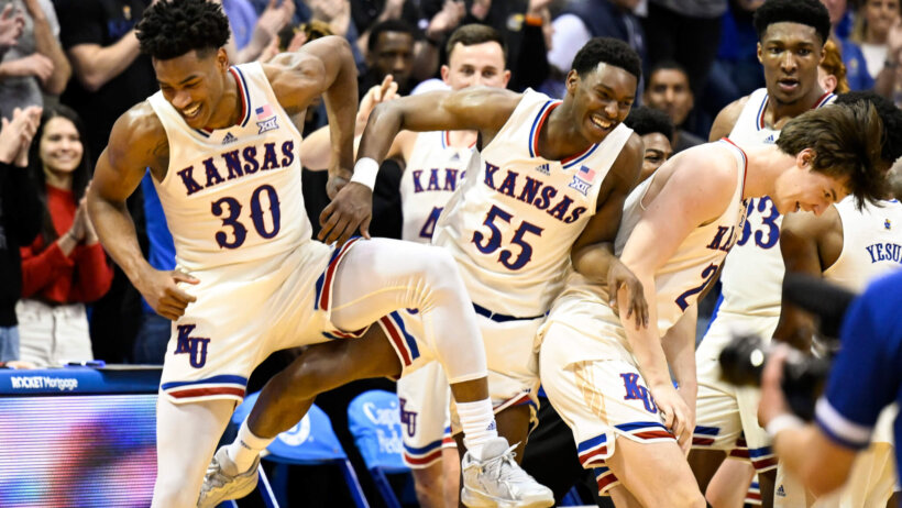 Kansas guards Ochai Agbaji and Jalen Coleman-Lands celebrate a win with teammate Zach Clemence