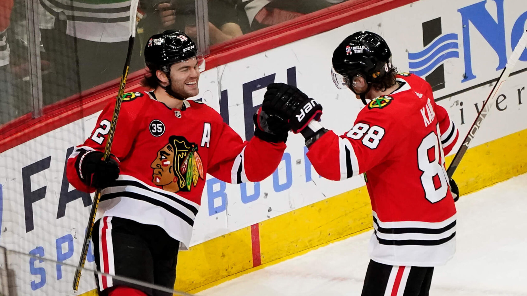 Chicago Blackhawks' Alex DeBrincat celebrating a goal with Patrick Kane