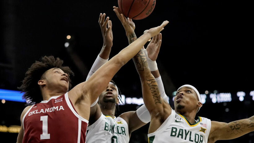 Baylor forward Flo Thamba and guard James Akinjo going after a rebound
