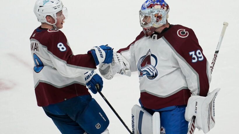 Colorado Avalanche defenseman Cale Makar celebrating with goalie Pavel Francouz
