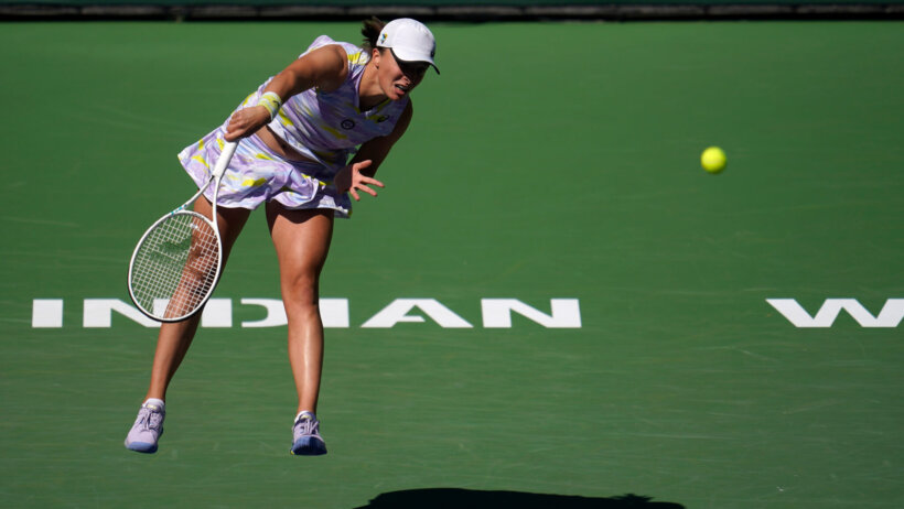 Iga Swiatek serving to her opponent during a tennis match.