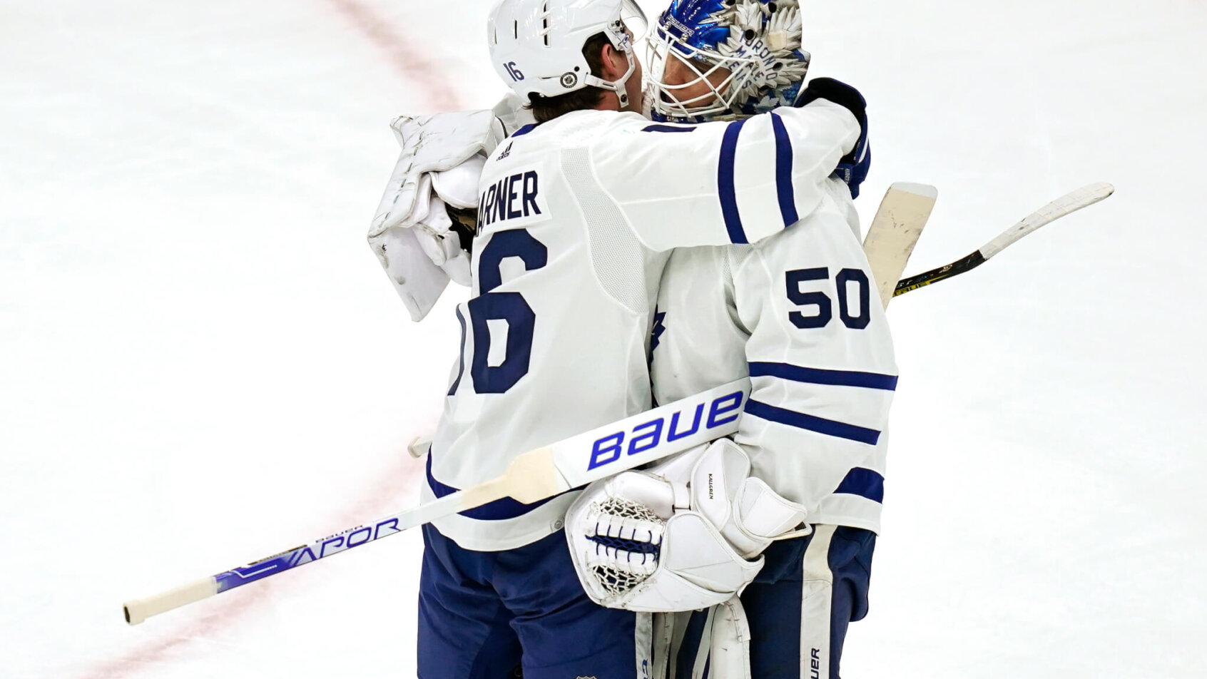 Erik Kallgren embraced by Mitchell Marner