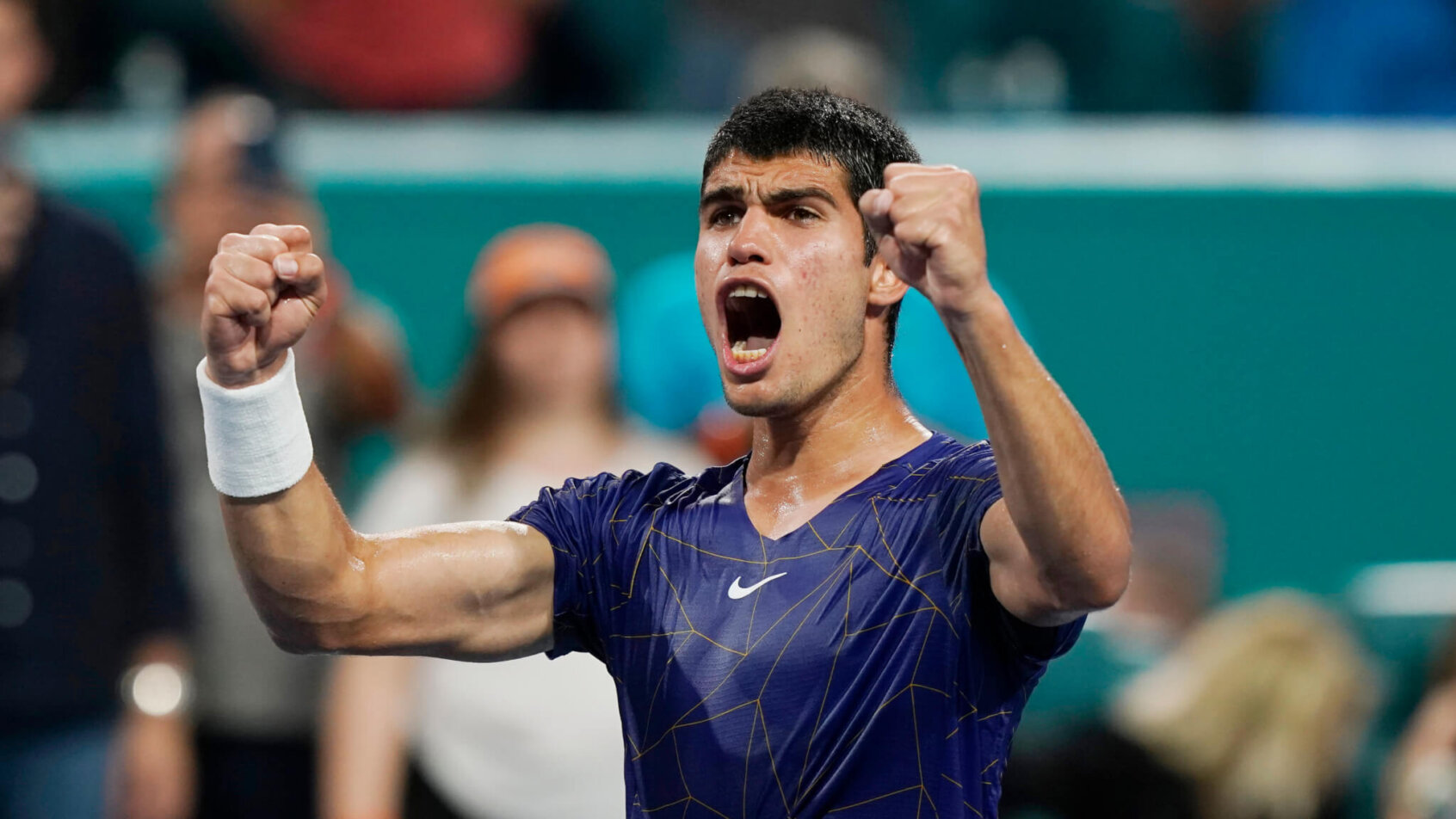 Carlos Alcaraz celebrating after winning a tennis match.