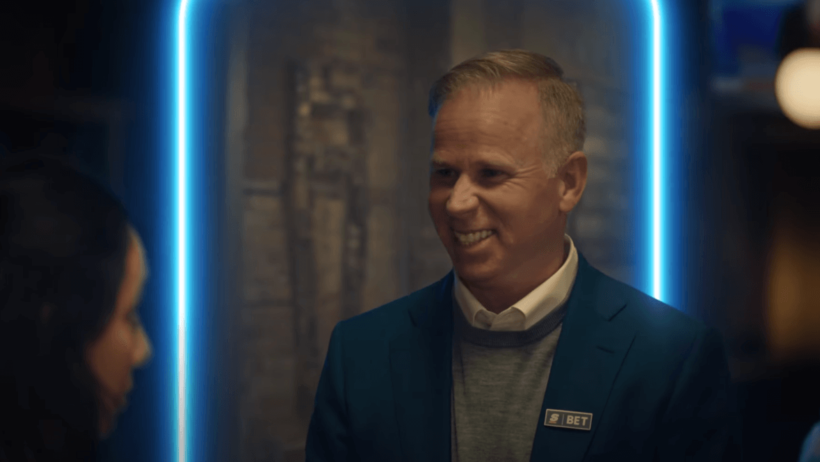 Gerry Dee Score Bet badge blue jacket