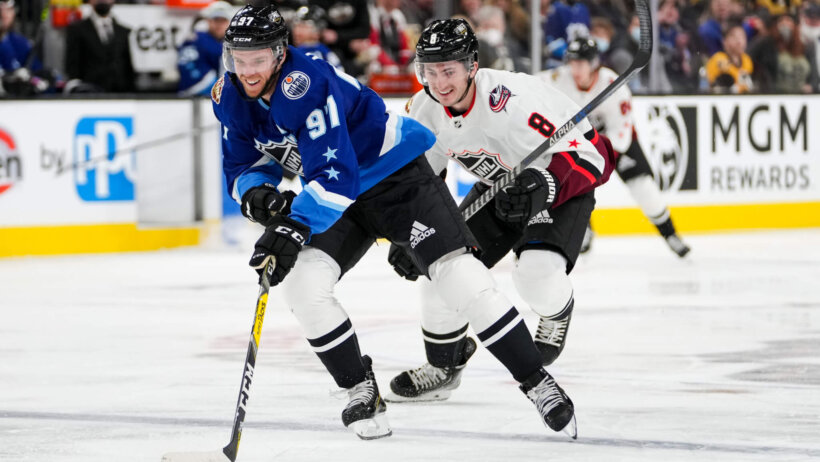 Connor McDavid skating with puck blue jersey all star game