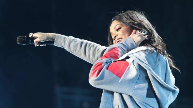 Rihanna hand on ear pointing with mic