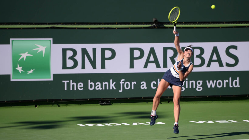 Barbora Krejcikova hitting a serve during a tennis match.