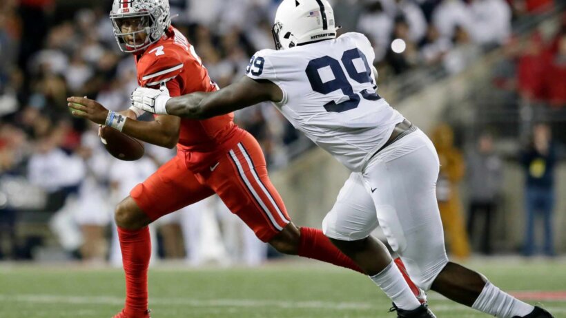 Ohio State Buckeyes quarterback C.J. Stroud is pursued by Penn State Nittany Lions defensive tackle Coziah Izzard