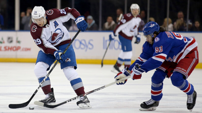 Colorado Avalanche center Nathan MacKinnon controls the puck against New York Rangers center Mika Zibanejad