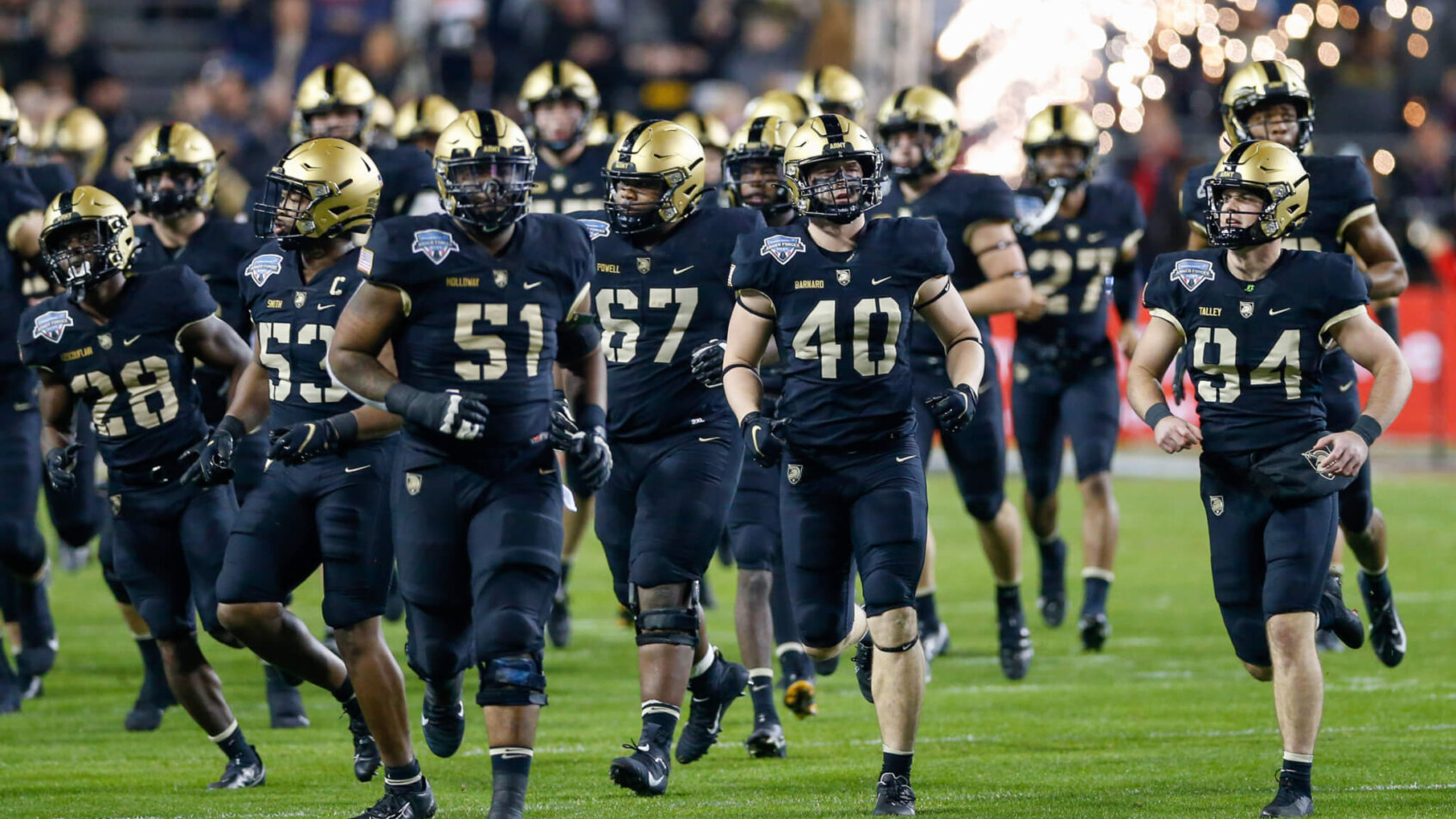 The Army Black Knights run onto the field