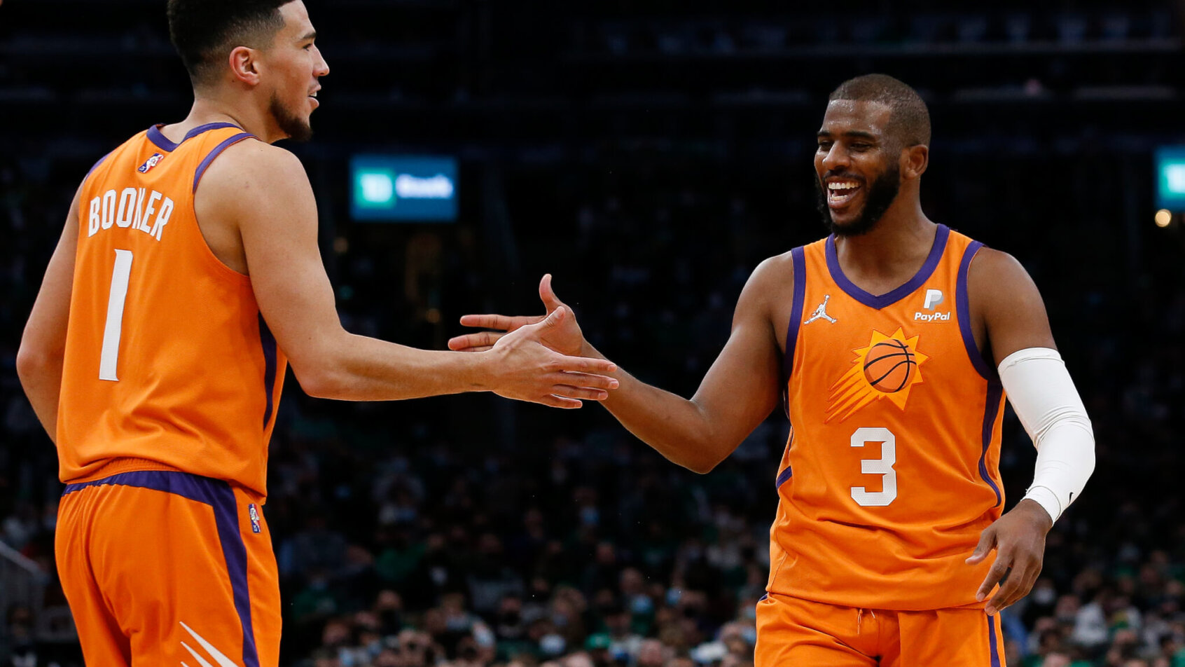 Devin Booker giving five to Chris Paul