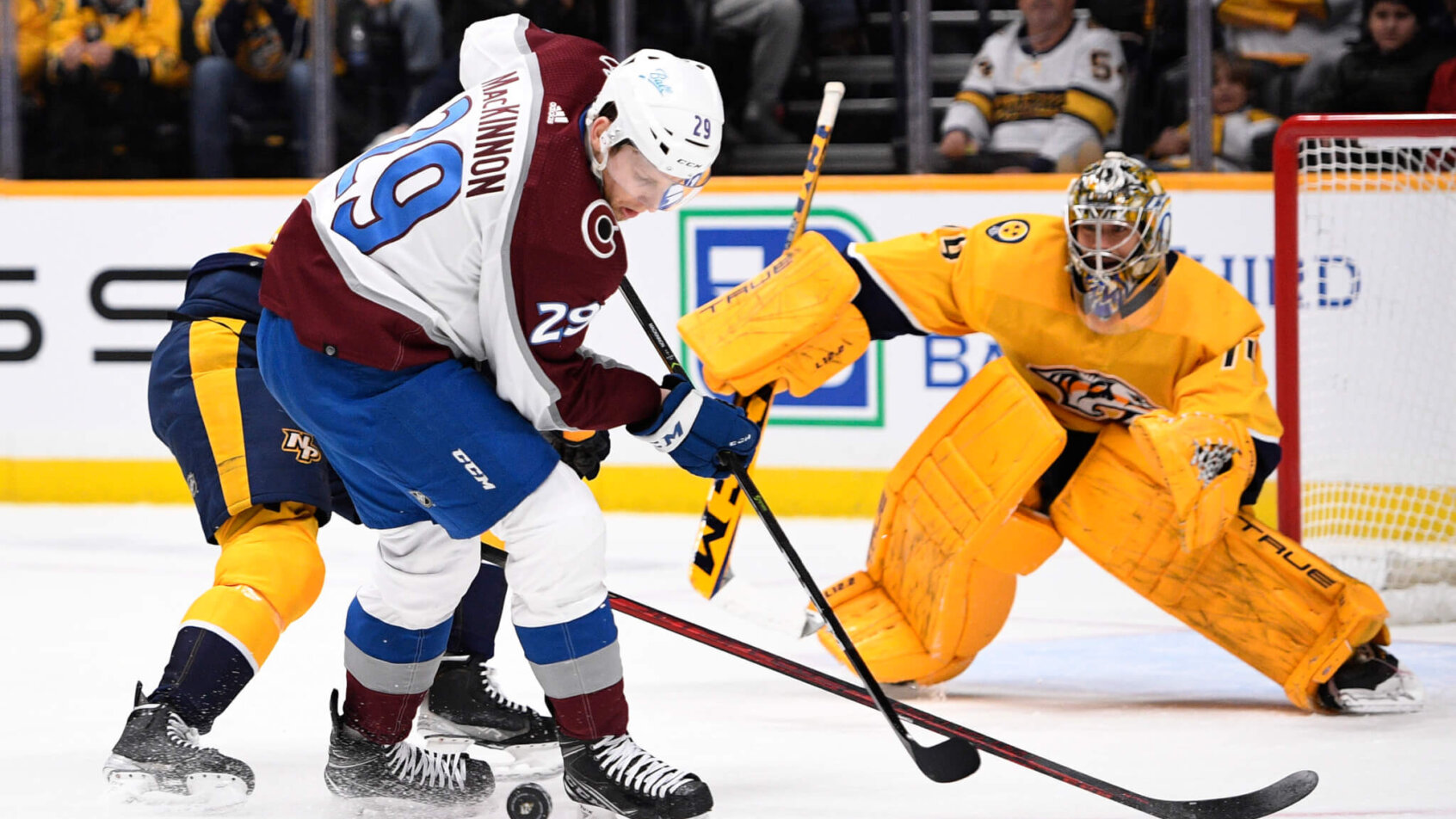 Nathan MacKinnon battling for puck in front of net