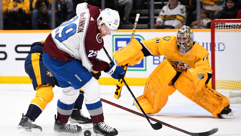 Nathan MacKinnon battling for puck in front of net