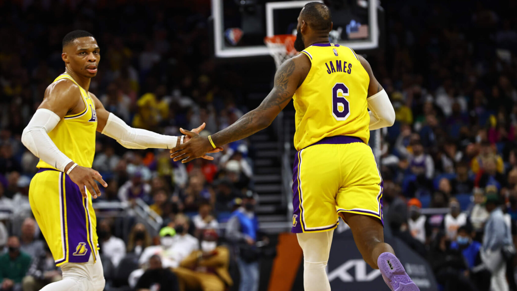 Lebron James and Russell Westbook high fiving on the court during an NBA game.