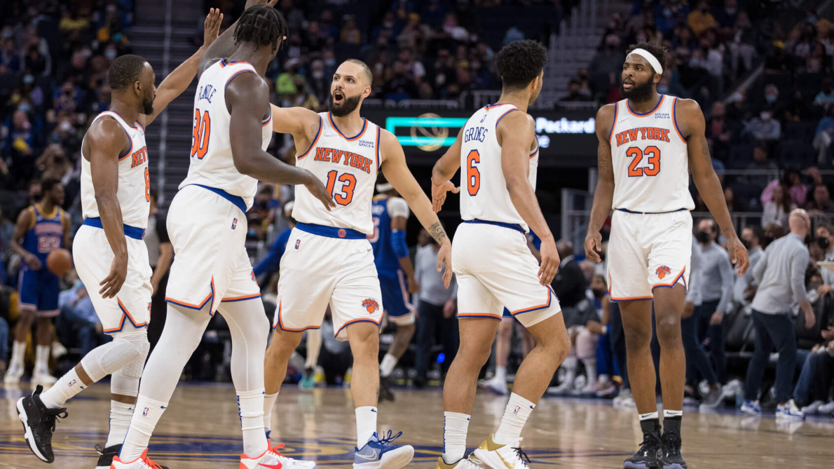 New York Knicks players high fiving each other on the court.