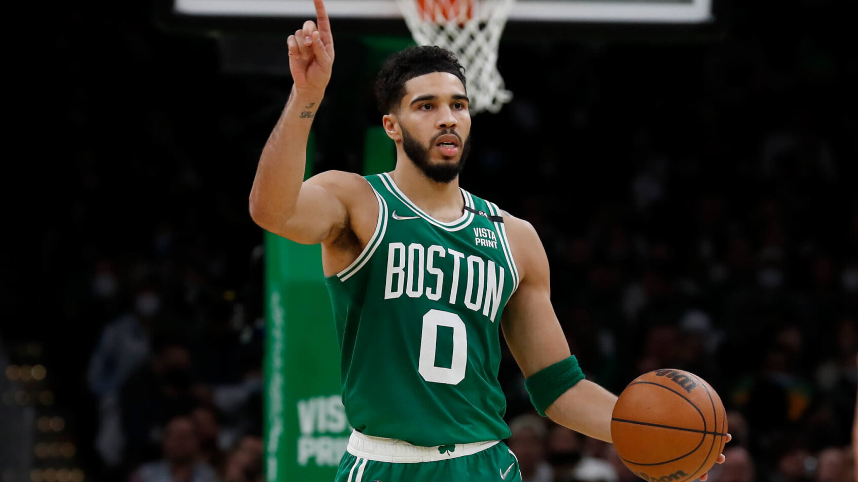 Boston Celtics forward Jayson Tatum dribbling the ball up the court during an NBA game.