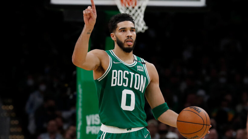 Boston Celtics forward Jayson Tatum dribbling the ball up the court during an NBA game.