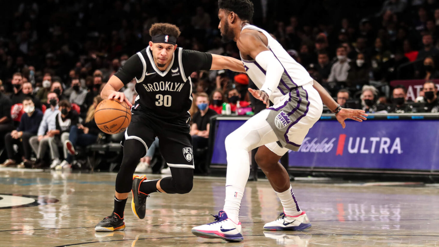 Seth Curry dribbling against defender