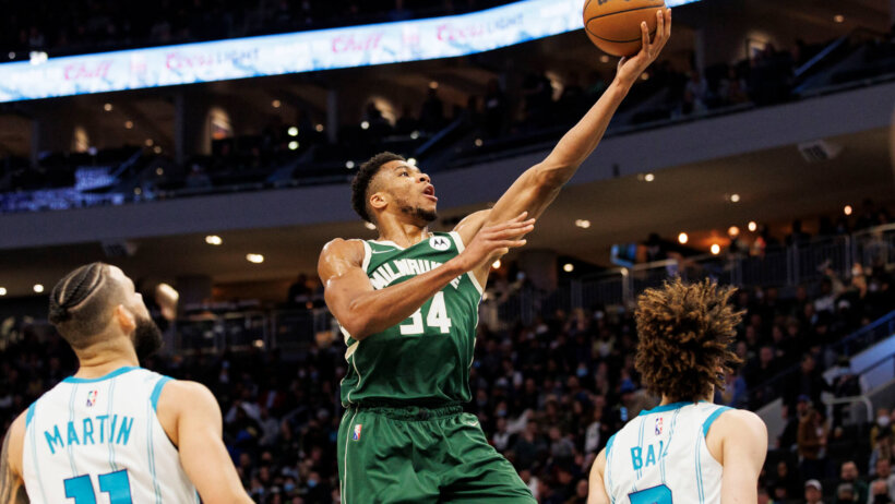 Giannis Antetokounmpo laying ball in
