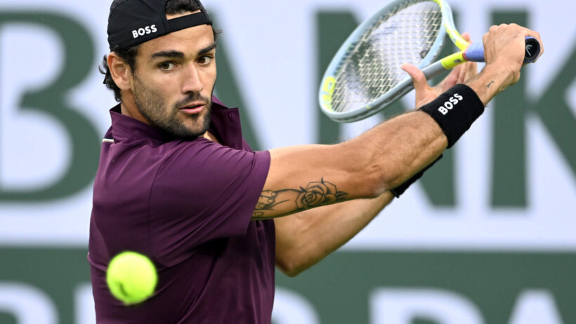 Matteo Berrettini hitting a ball during a tennis match.