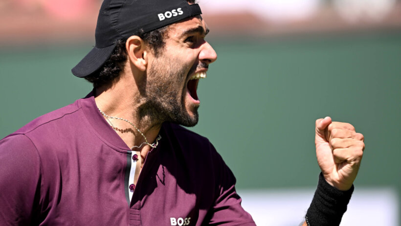 Matteo Berrettini celebrating with a fist pump during a tennis match.