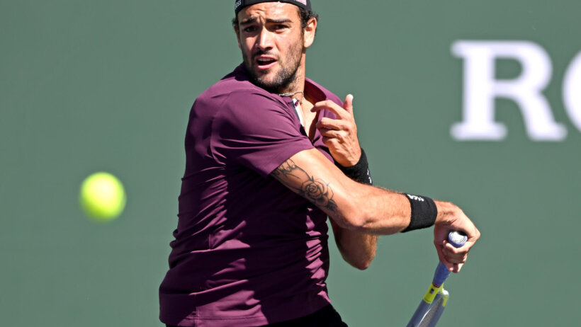 Matteo Berrettini hitting a shot during a tennis match.