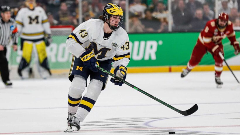 Michigan defenseman Luke Hughes looks to pass the puck