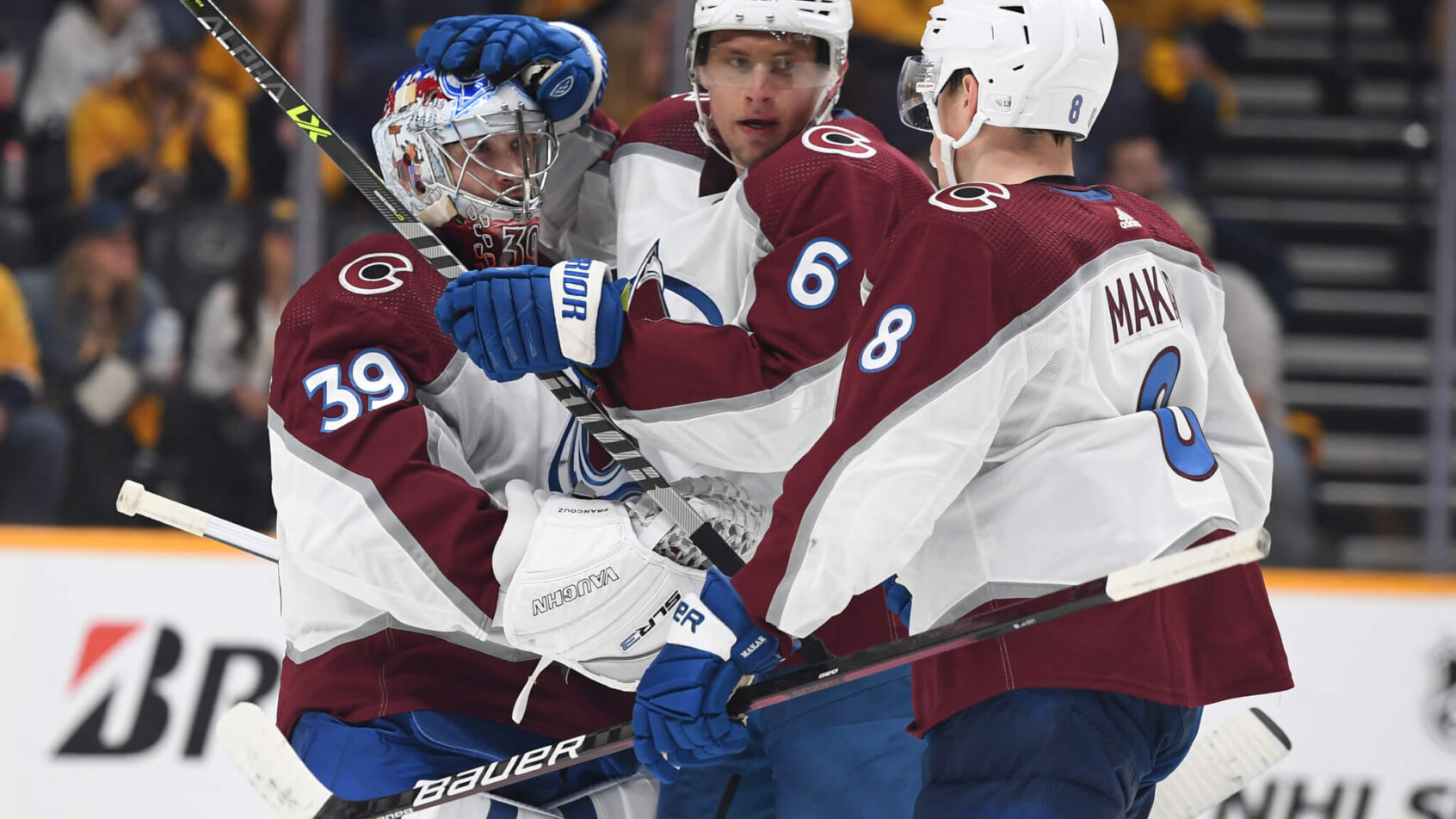 Colorado Avalanche goaltender Pavel Francouz celebrating with defensemen Erik Johnson and Cale Makar after a win